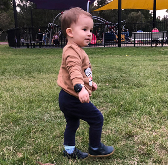 Toddler wearing an activity watch, while walking in a playground